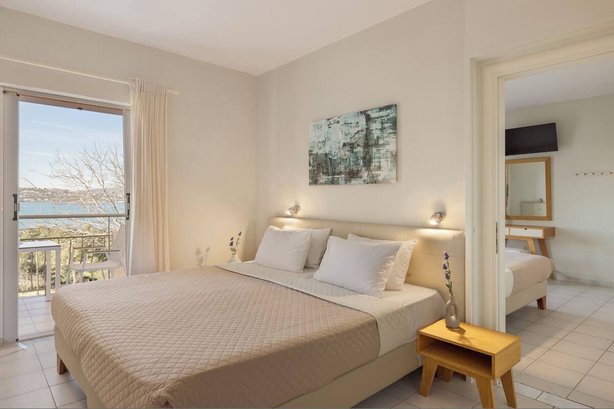 Een slaapkamer met een bed, nachtkastje en een schilderij aan de muur.