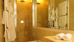 A modern bathroom with a walk-in shower, a bidet, and a toilet. There are towels and robes hanging on a rack. - 1865 Residenza D'epoca (Florence)
