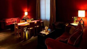A room with a dining area, a sofa, and a red couch. - 1865 Residenza D'epoca (Florence)