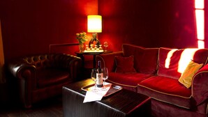 A red velvet sofa, a leather armchair, and a small table with a bottle and glasses. - 1865 Residenza D'epoca (Florence)
