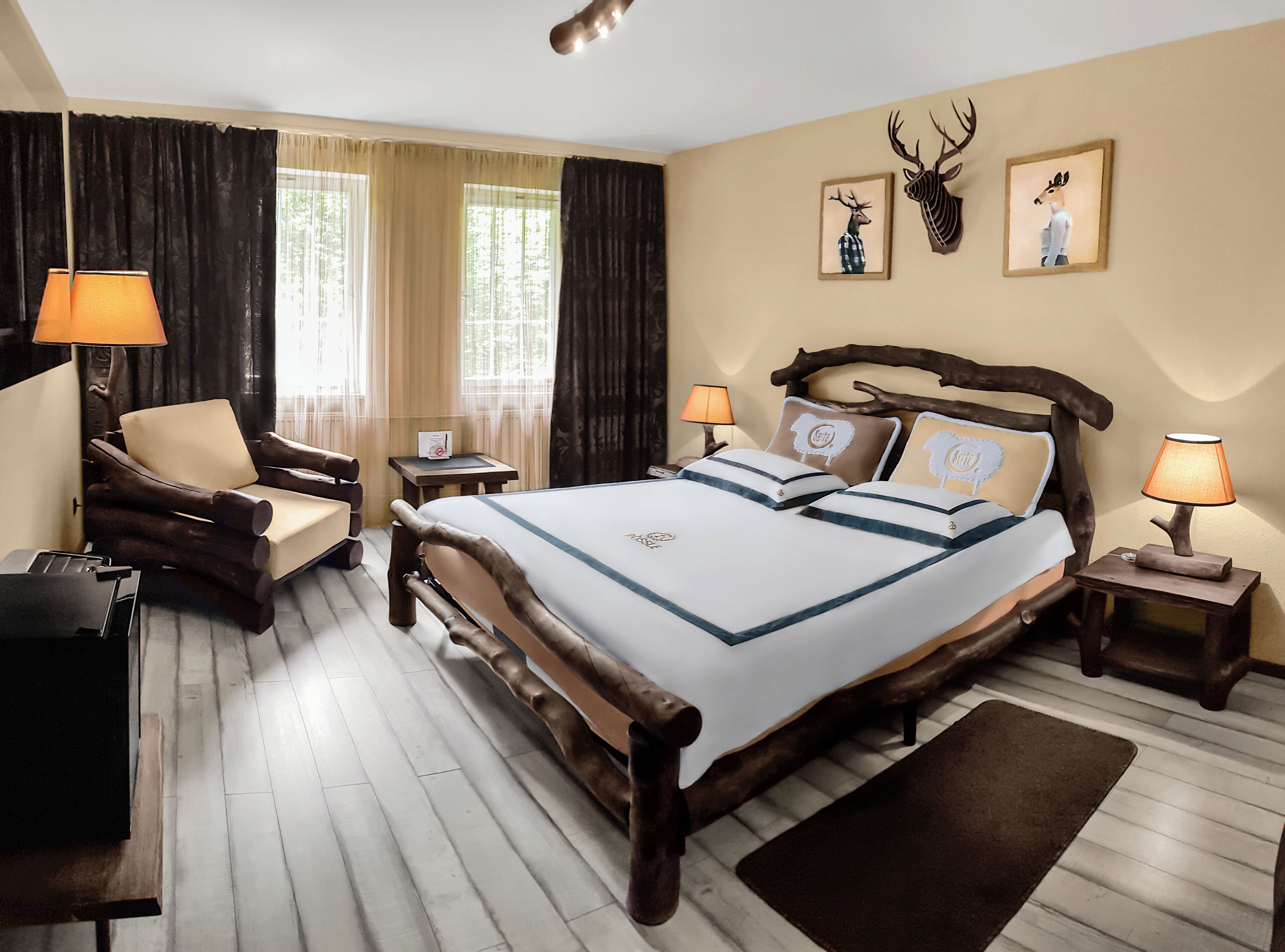 Une chambre d’hôtel avec un grand lit, une tête de lit en bois, deux tables de chevet avec des lampes, une chaise, un bureau et des rideaux.