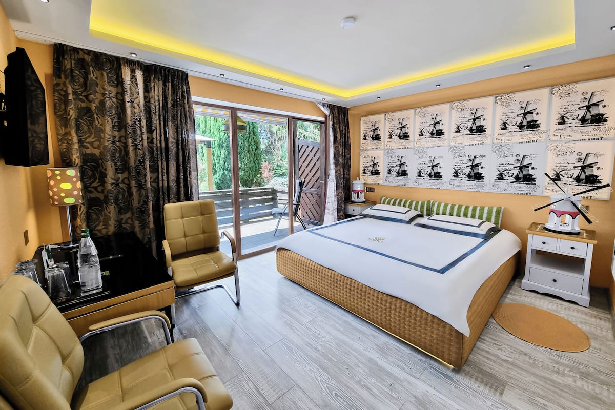 Habitación de hotel con una cama grande, un escritorio, una silla y vistas al exterior.