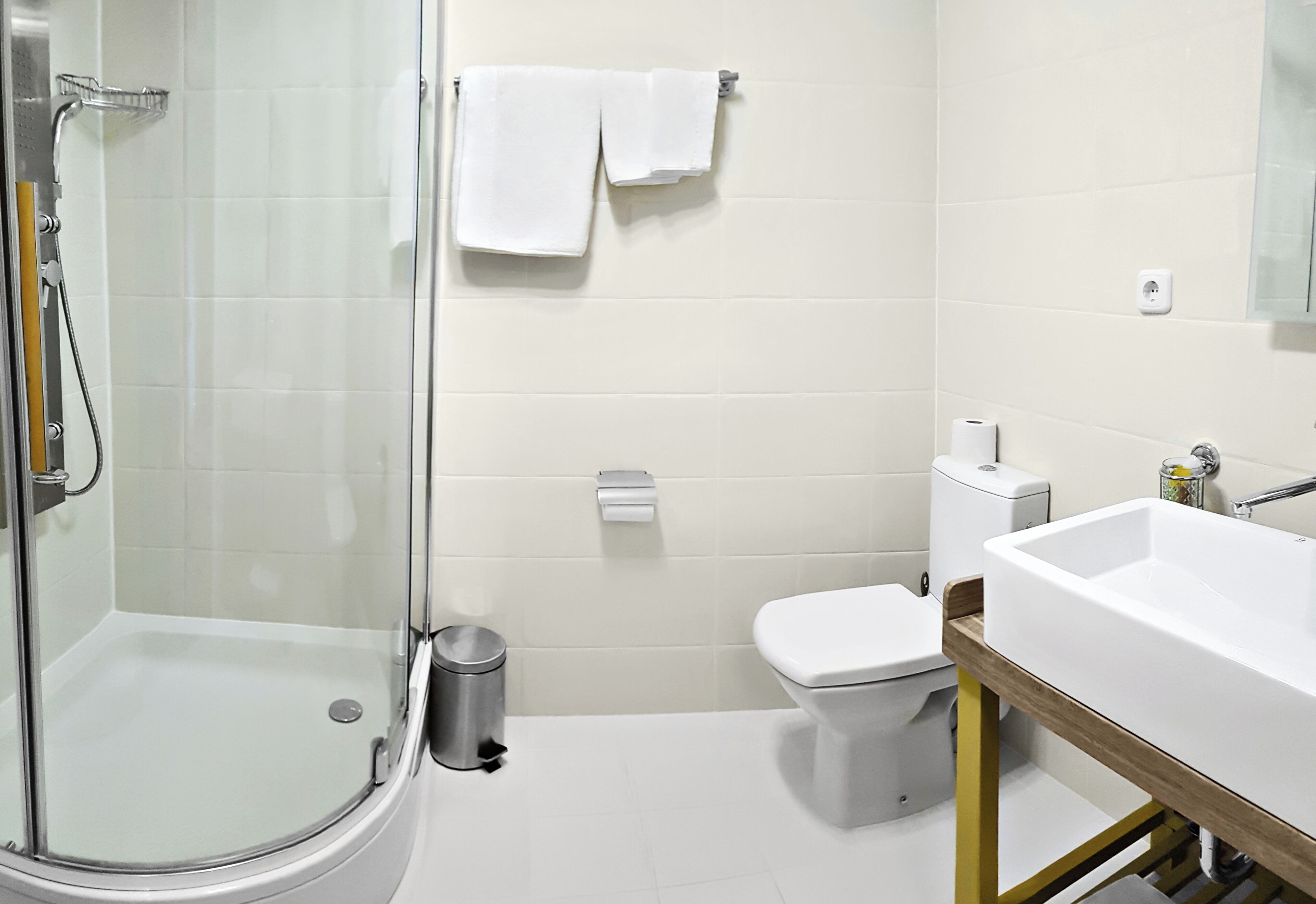 Ein modernes Badezimmer mit Duschkabine aus Glas, Toilette und Waschbecken.
