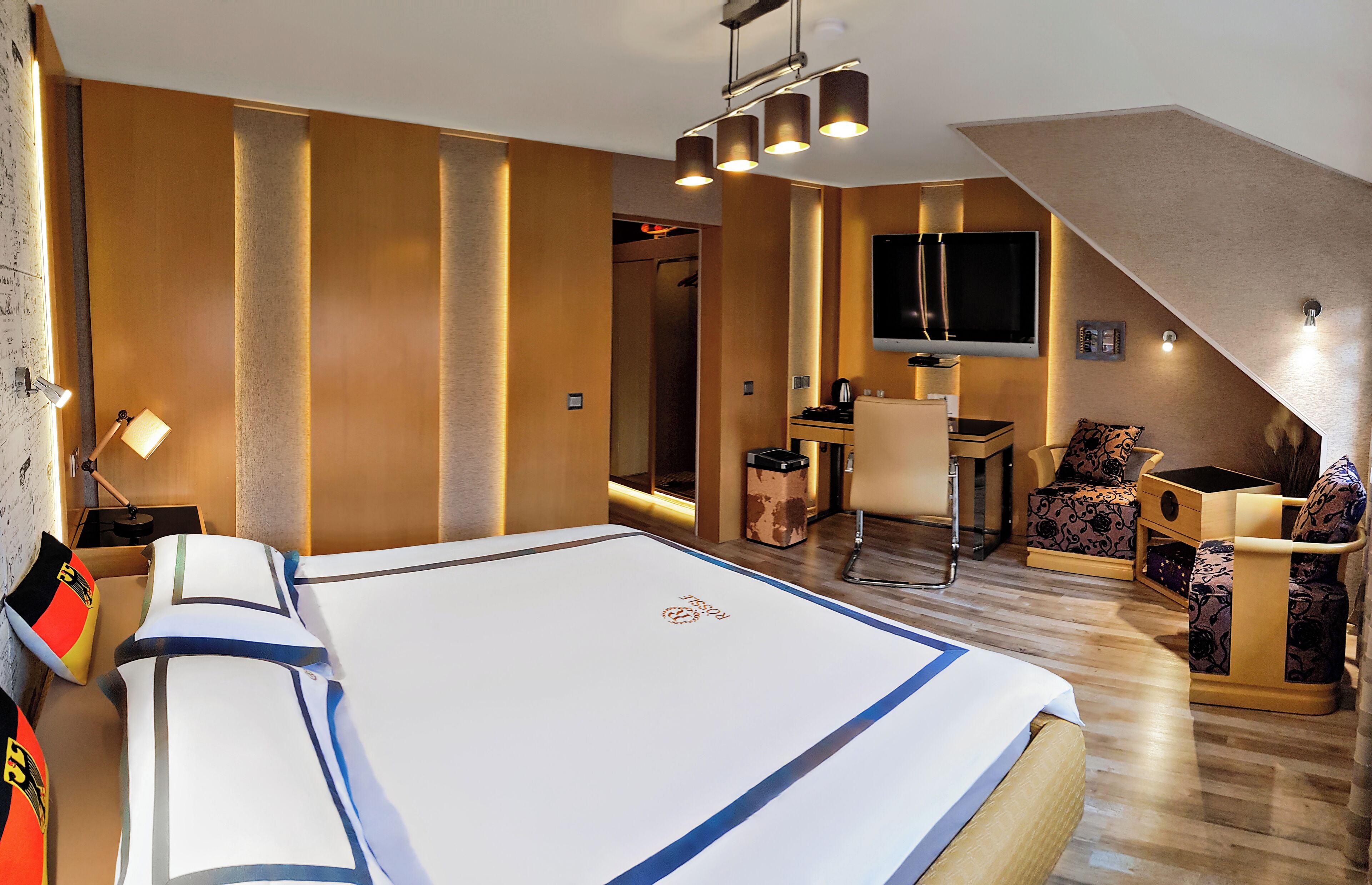 Une chambre d’hôtel moderne, dotée d’un grand lit, d’un bureau et d’un canapé.