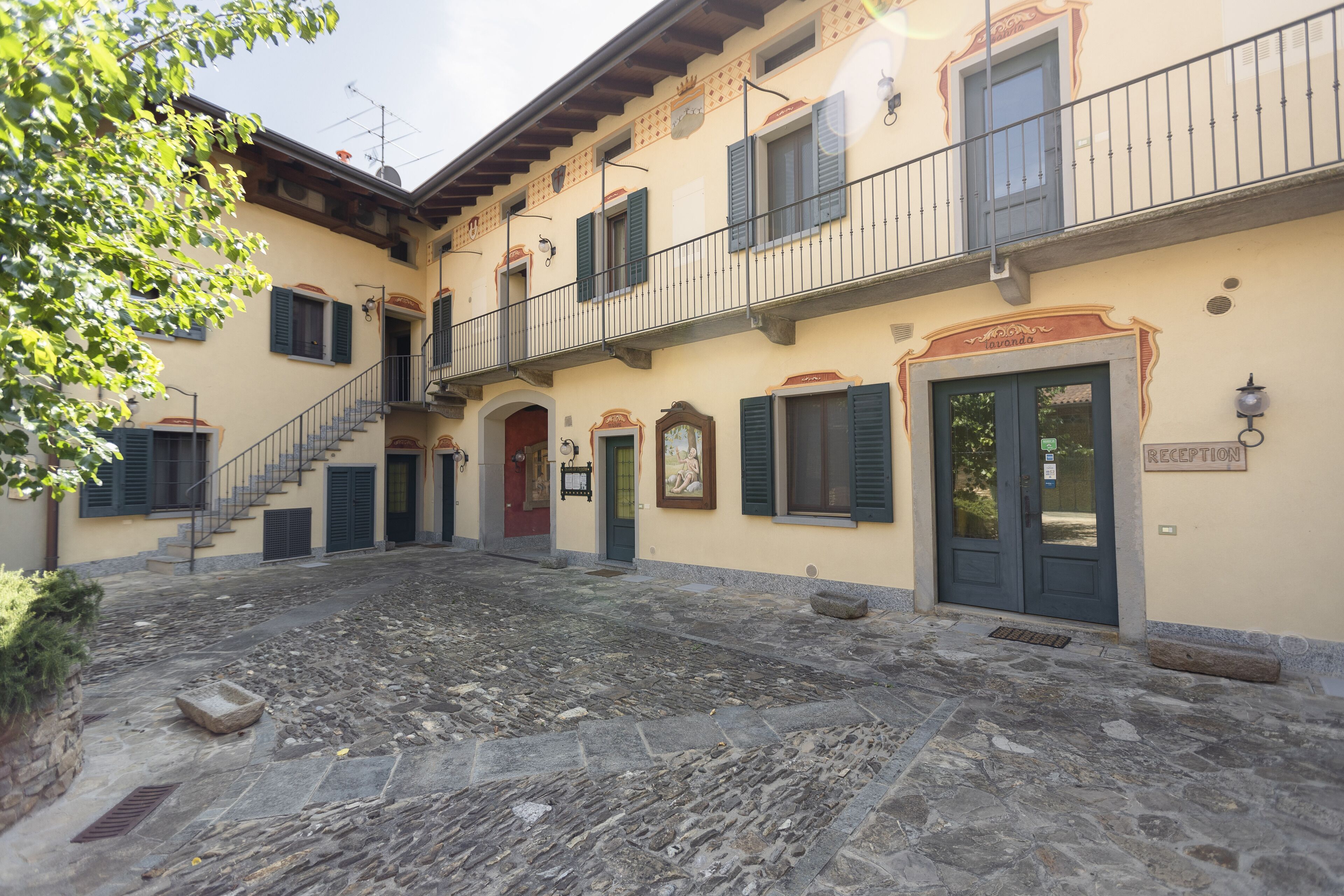 A building with a reception area, a staircase, and a courtyard with stone flooring.