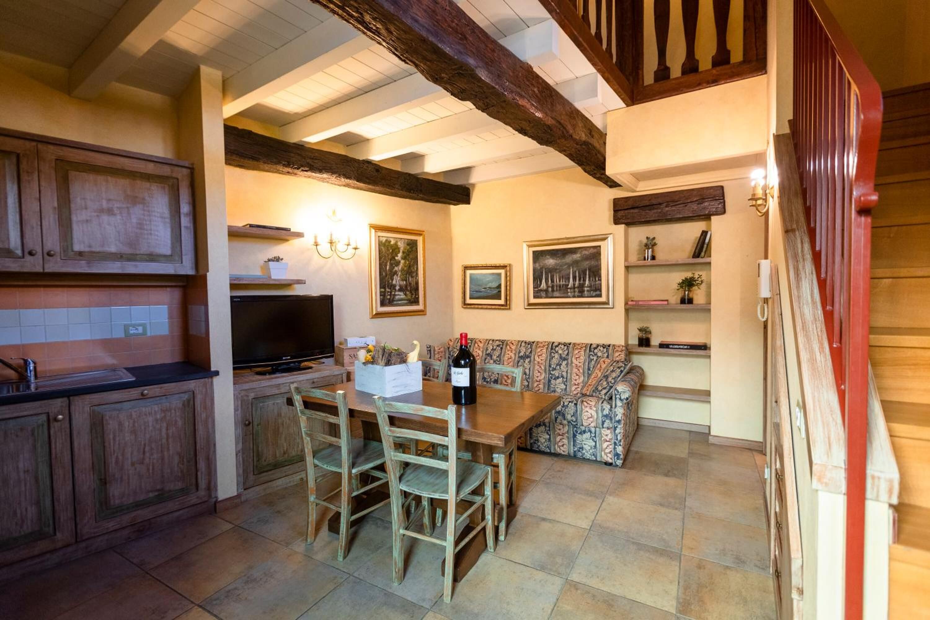 Una cocina acogedora con armarios de madera, una mesa de comedor y una escalera roja.