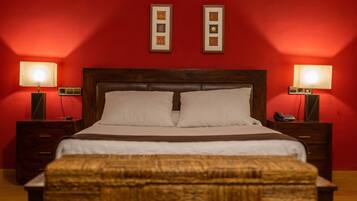 A neatly made bed with two pillows, a wooden headboard, and two bedside tables with lamps.