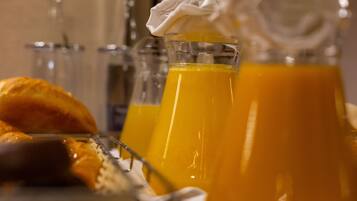 A breakfast setting with orange juice, a croissant, and a knife on a plate.