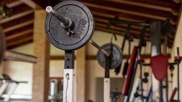 A weightlifting area with a barbell marked 10kg, a bench press, and various other gym equipment.
