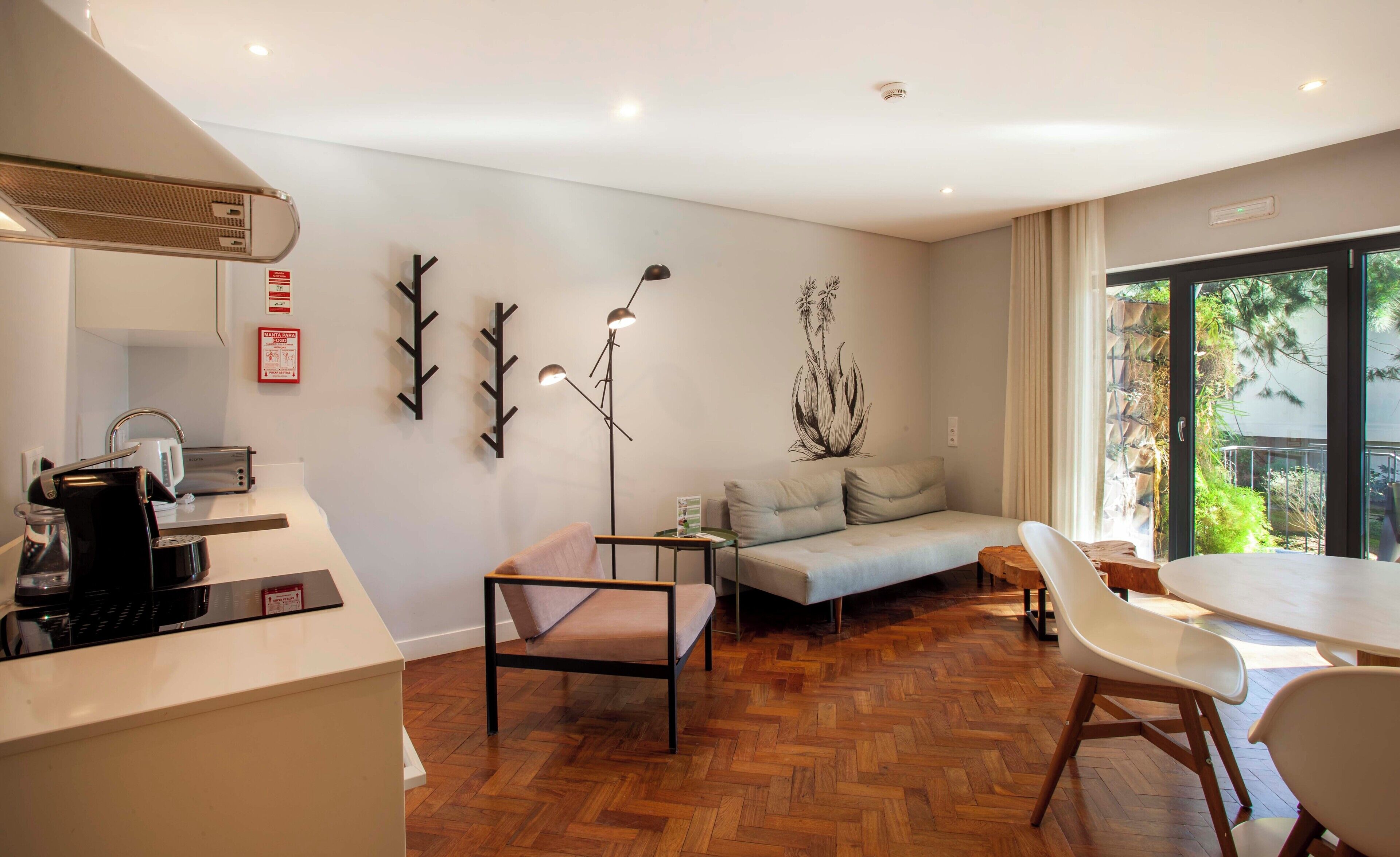 Een moderne woonkamer met een bank, een eettafel en een koffieapparaat.