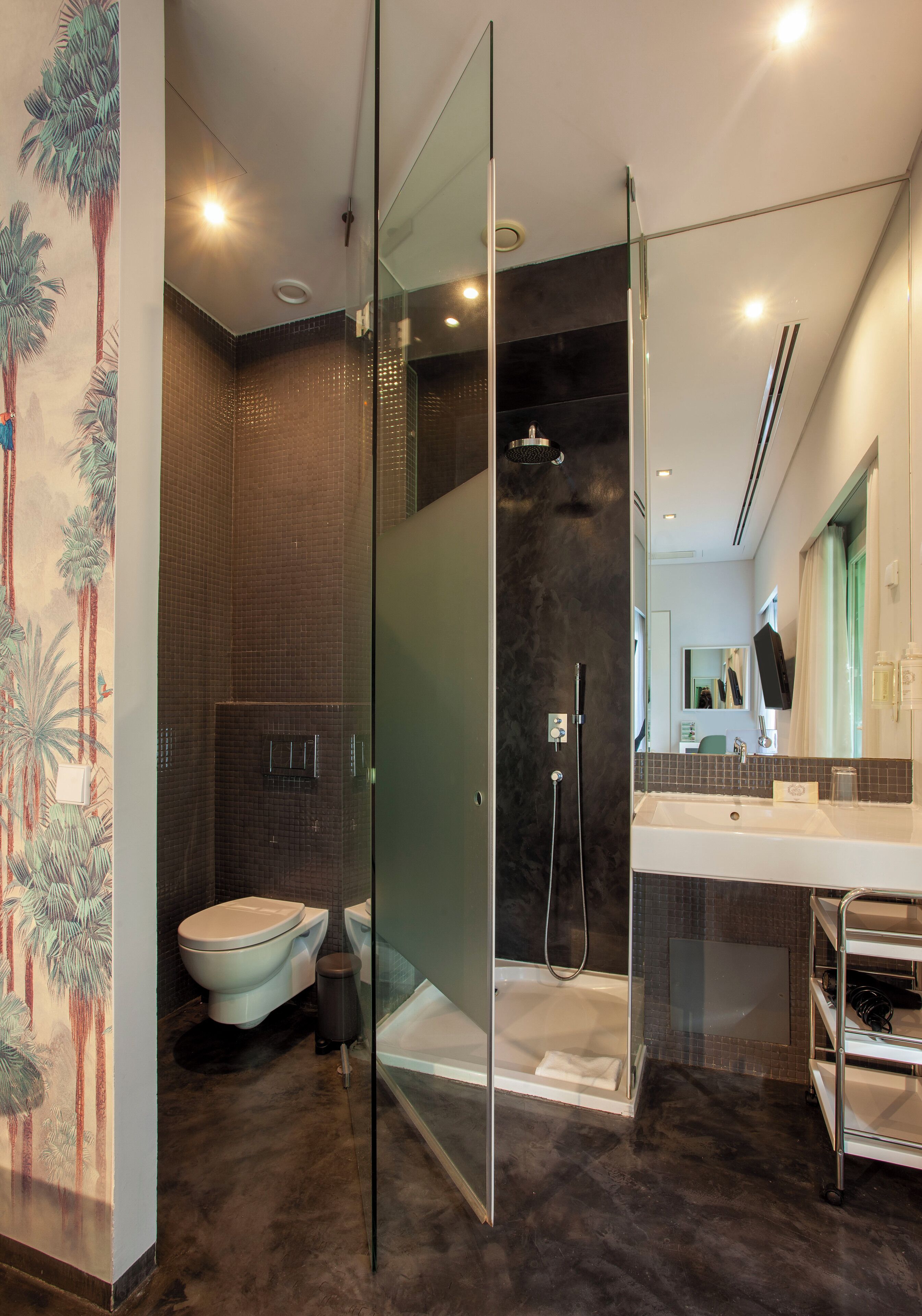 Een moderne badkamer met een douchecabine van glas, een wit wastafelmeubel en een toilet.