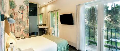 A bedroom with a bed, a bathroom, a TV, and a balcony with outdoor furniture.