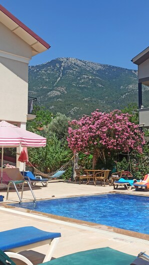 Una piscina al aire libre de temporada, sombrillas