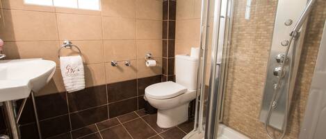 A bathroom with a sink, toilet, and shower.