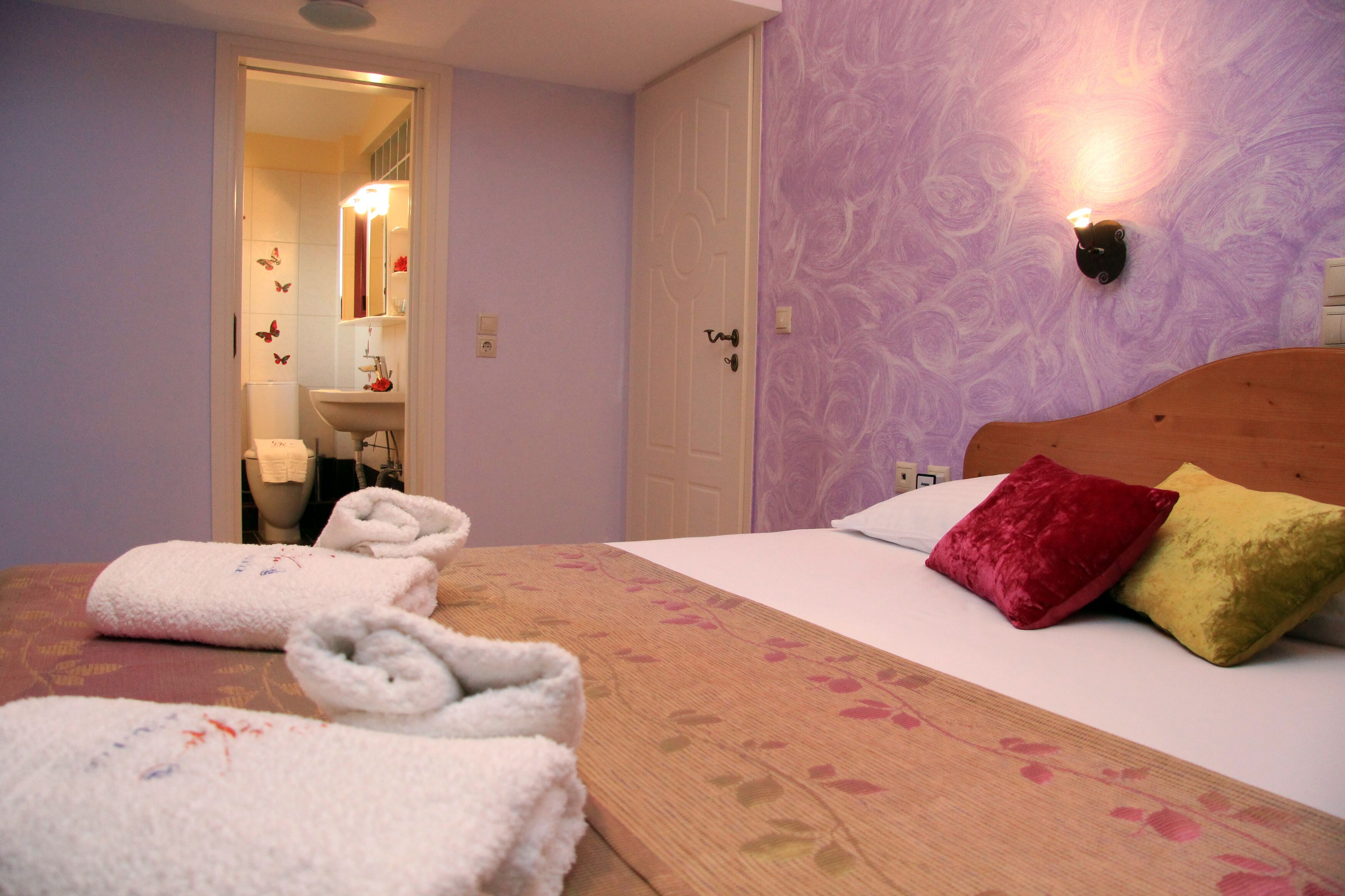A hotel room with a bed, pillows, and towels.