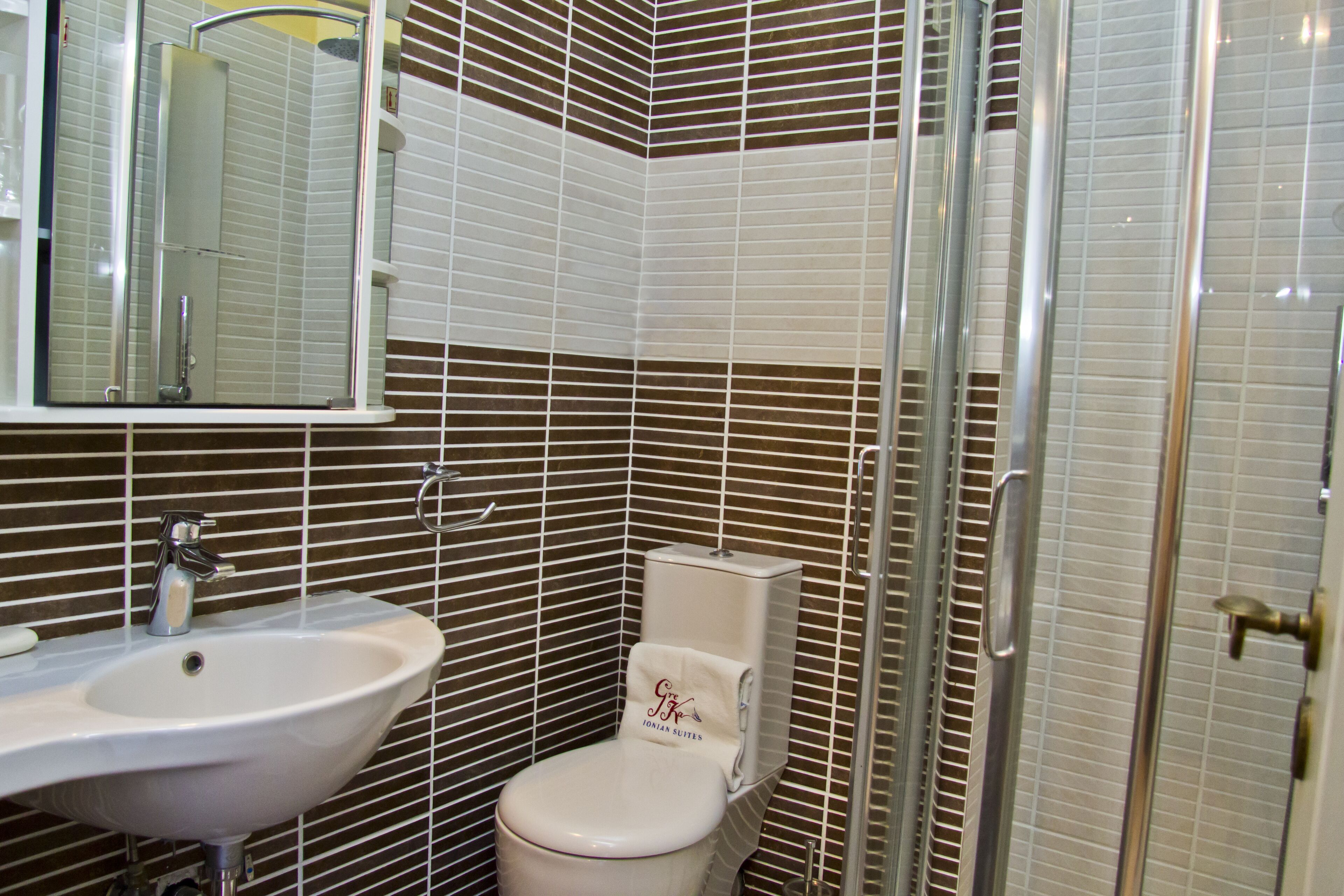 A bathroom with a sink, toilet, and shower.