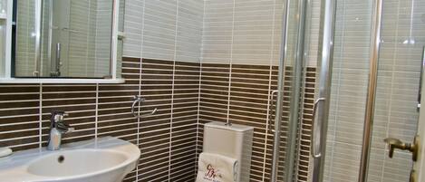 A bathroom with a sink, toilet, and shower.