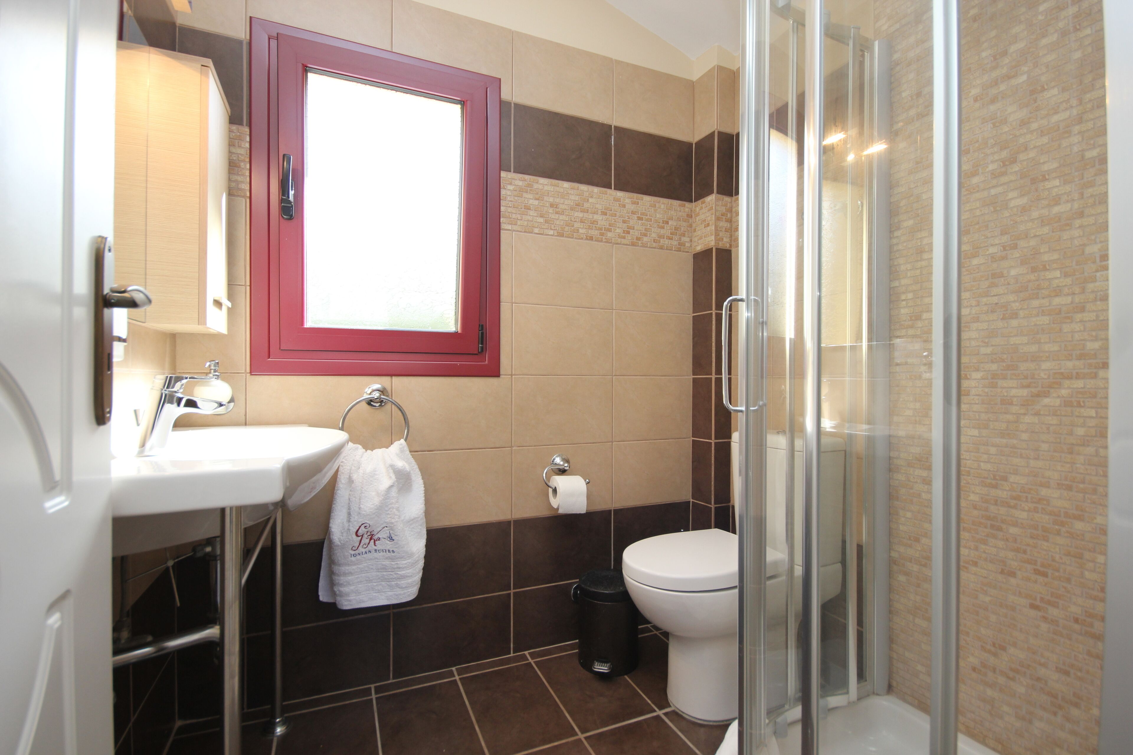 A bathroom with a sink, toilet, and glass shower enclosure.