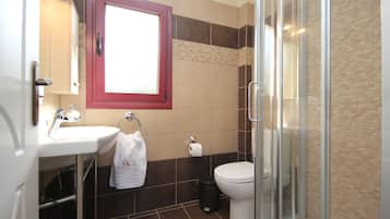 Un baño con lavabo, inodoro y cabina de ducha de vidrio.