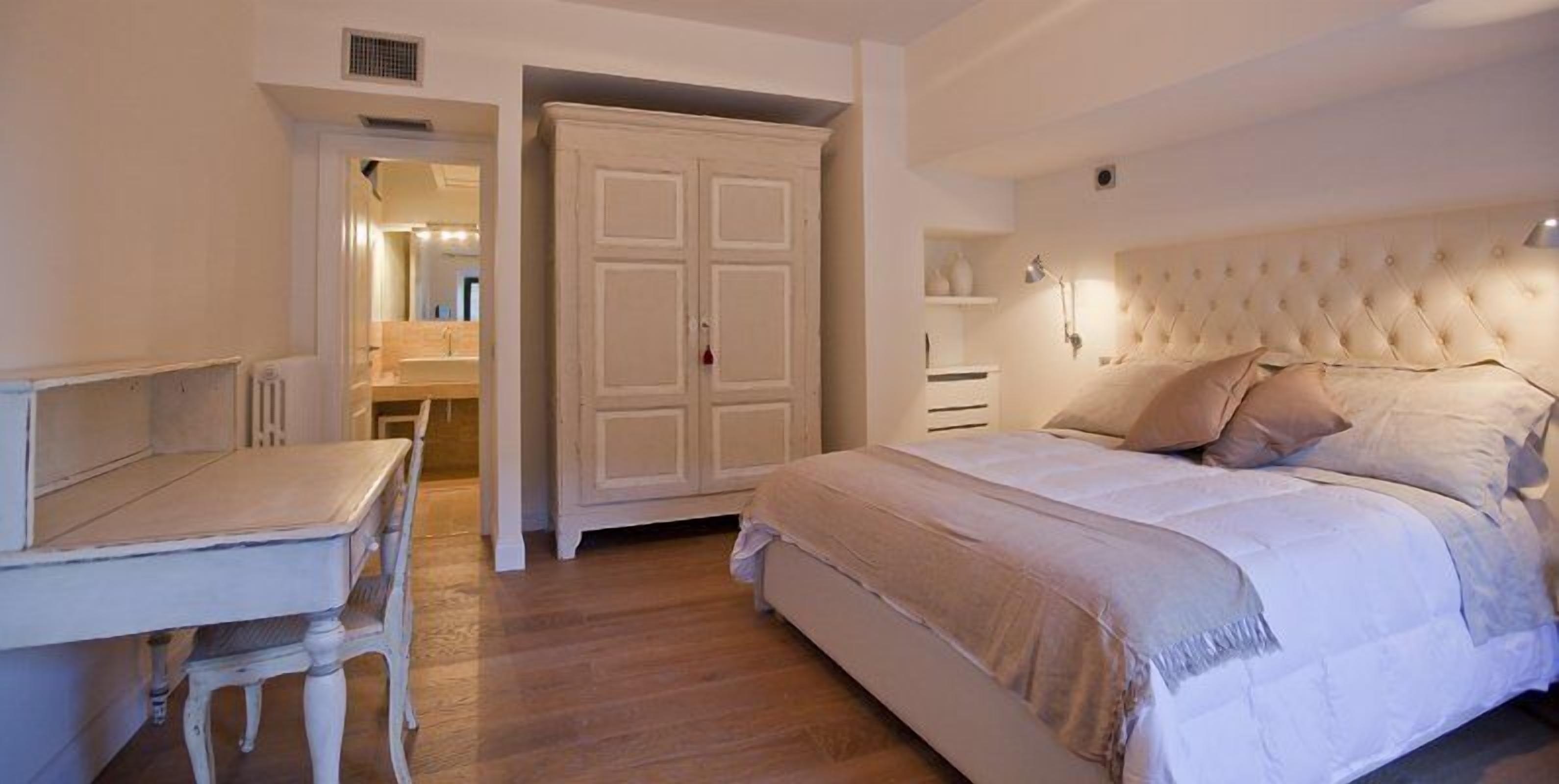 Un dormitorio con cama, escritorio y armario.