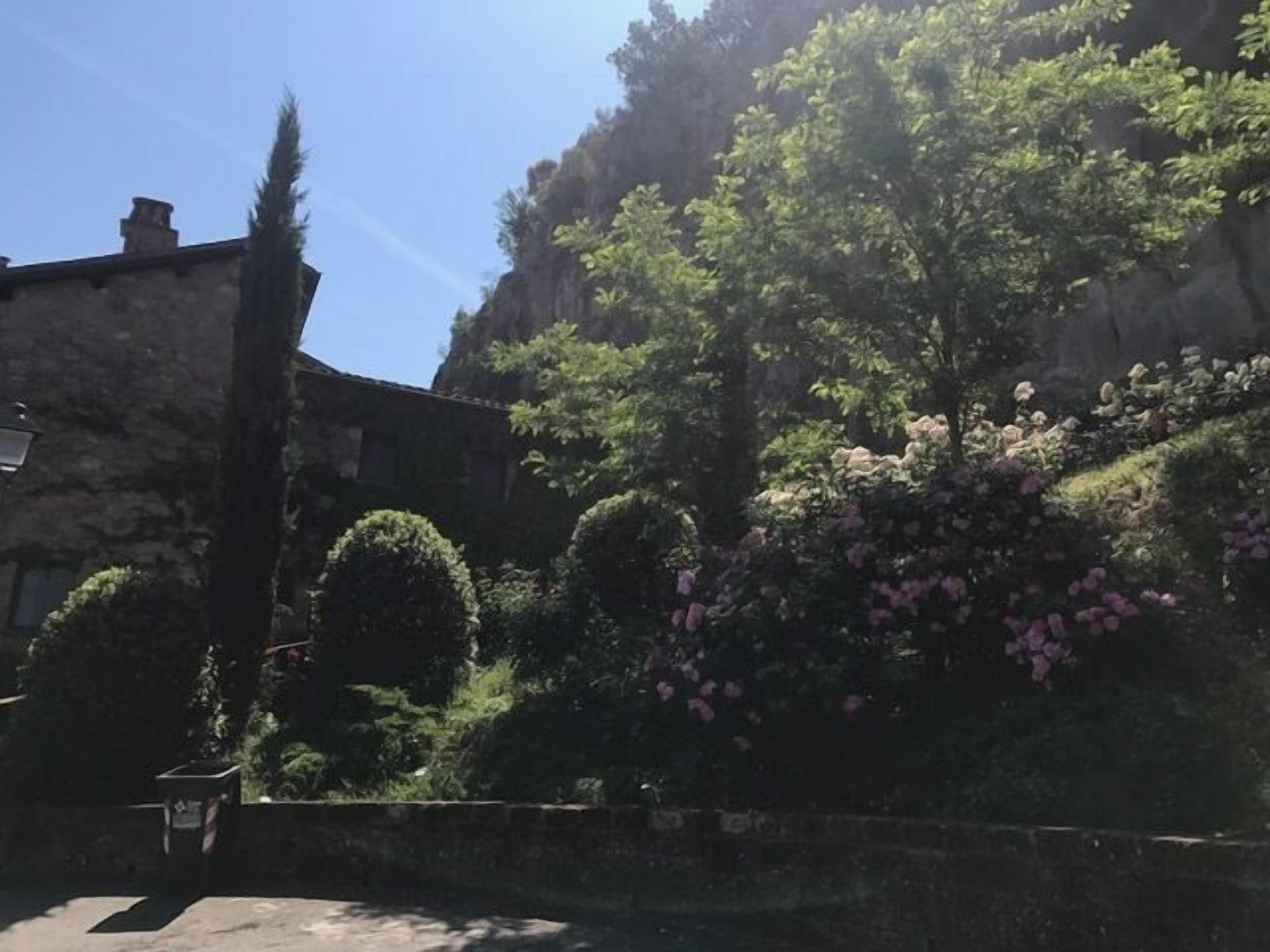 Ein Steinhaus mit Garten und einer Treppe, die davor führt.
