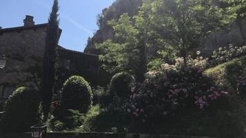 Ein Steinhaus mit Garten und einer Treppe, die davor führt.