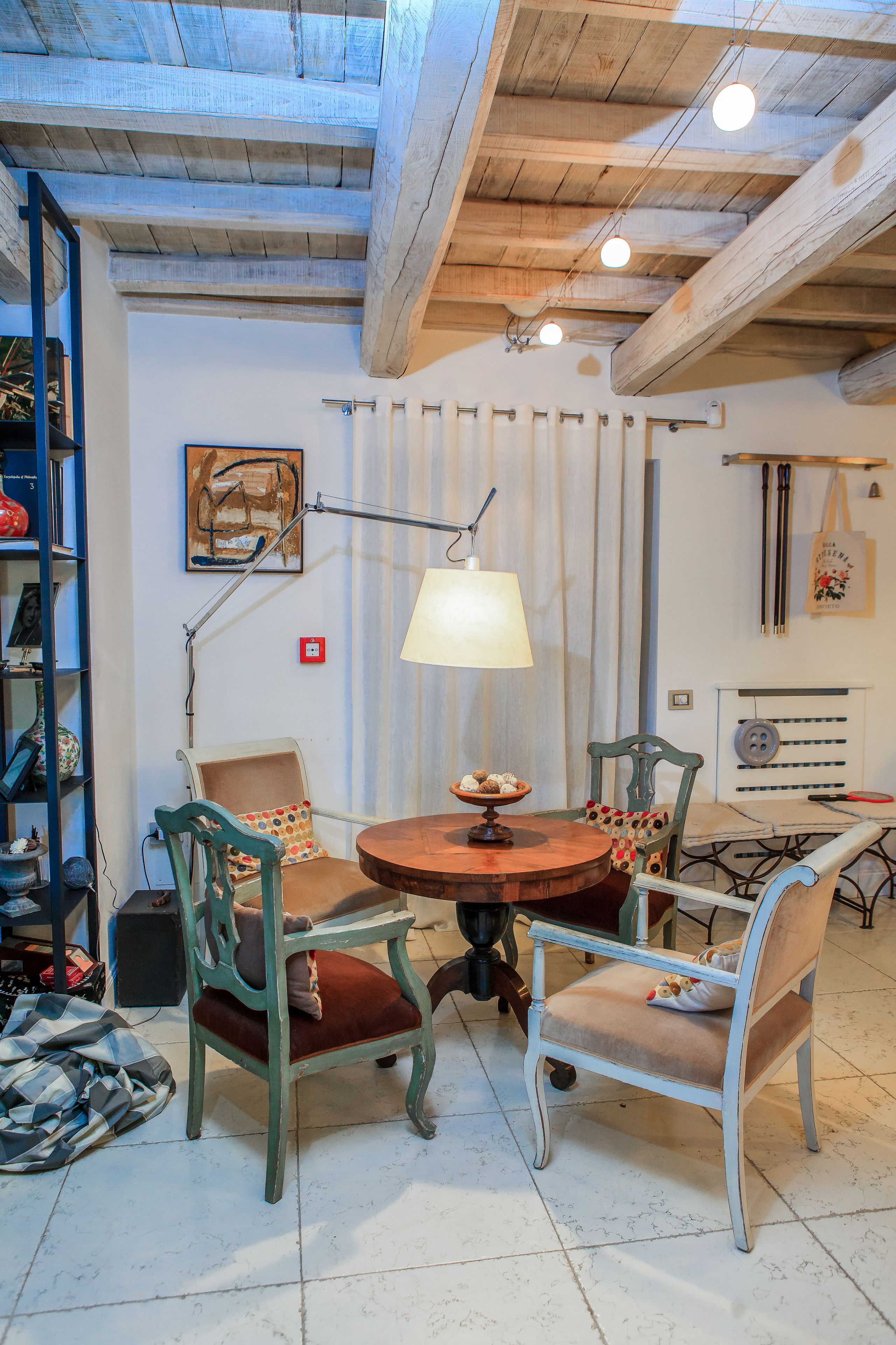A dining area with a wooden table, chairs, a lamp, and a radiator.