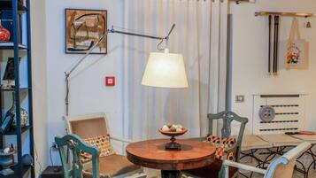 A dining area with a wooden table, chairs, a lamp, and a radiator.