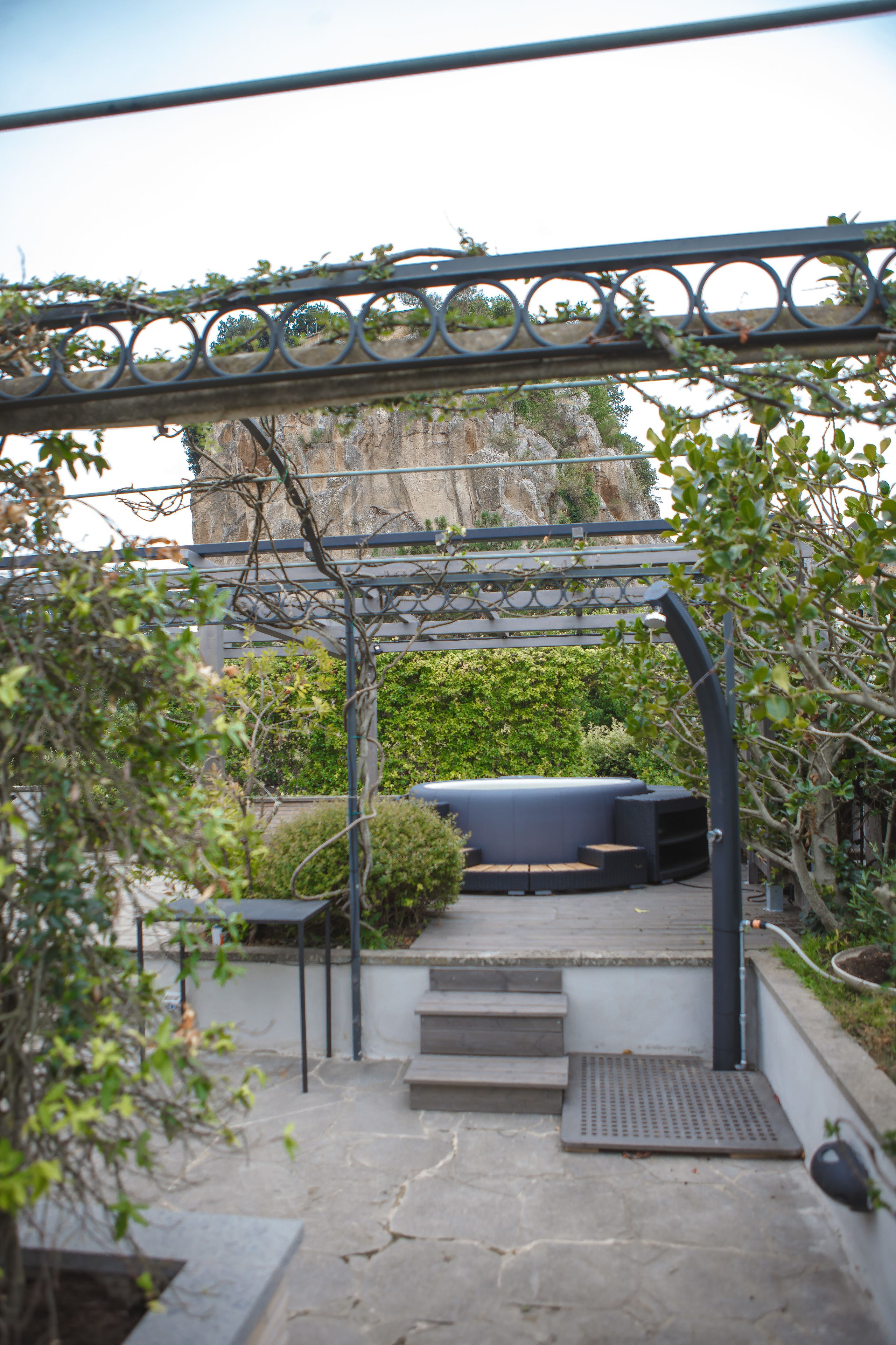 Un sendero de piedra que conduce a una zona de estar con una pérgola.