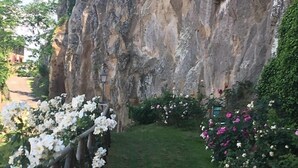 A pathway flanked by white and pink flowers leading to a rocky cliff. - Misia Country Resort (Orvieto)