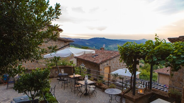 A patio with stone flooring, outdoor furniture, and a view of the countryside. - Misia Country Resort (Orvieto)