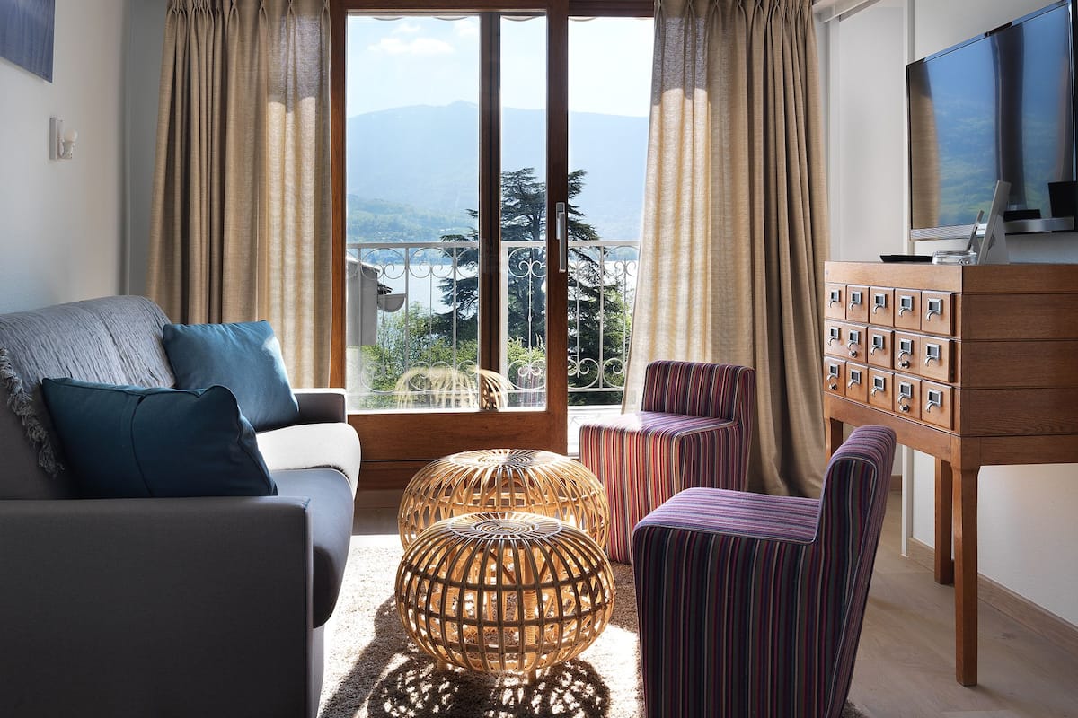 Un salon avec un canapé, des fauteuils, une table basse et un téléviseur.