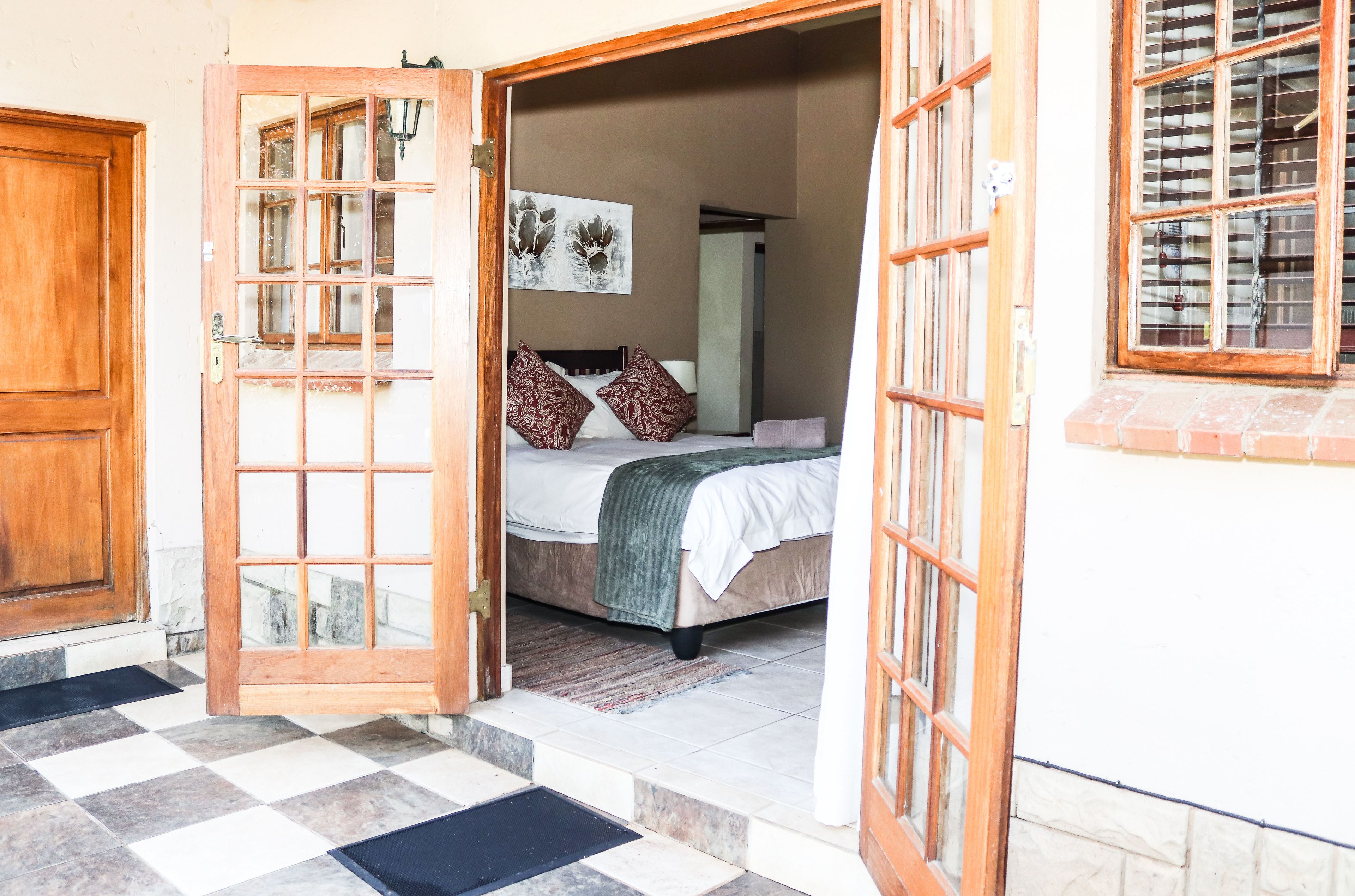 A room with a bed, a wooden door, and a window.