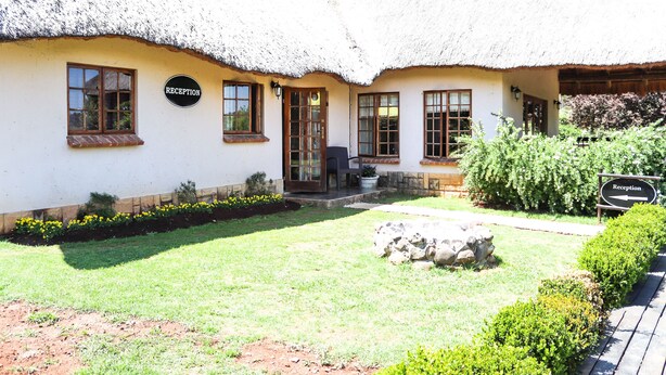 A thatched-roof building with a reception sign, a front door, and a small porch area. - The Old Hatchery (Drakensberg Gardens)