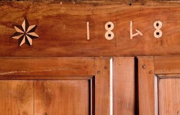 Un mur en bois orné d’un motif en forme d’étoile et sur lequel sont gravés les chiffres « 1818 ».