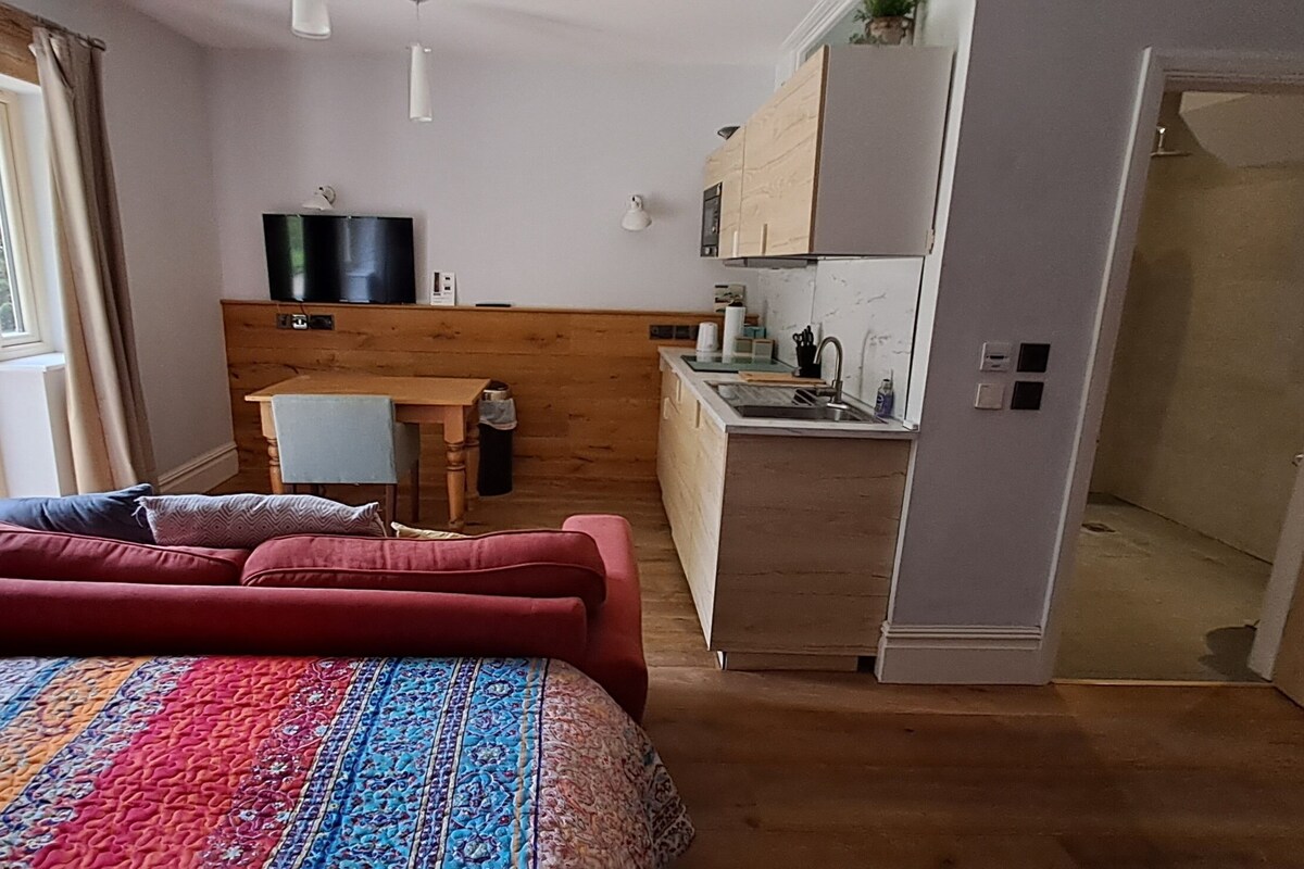 A cozy bedroom with a large bed, a wooden headboard, and a view of a balcony.
