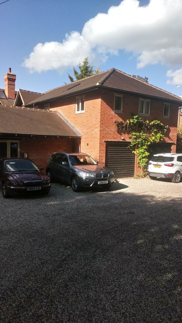 A two-story brick house with a gravel driveway.
