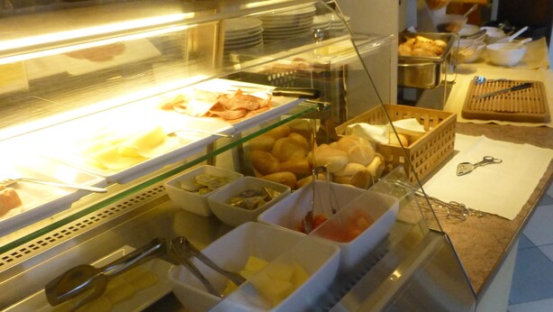 Zona de bufé con diversos alimentos y utensilios.