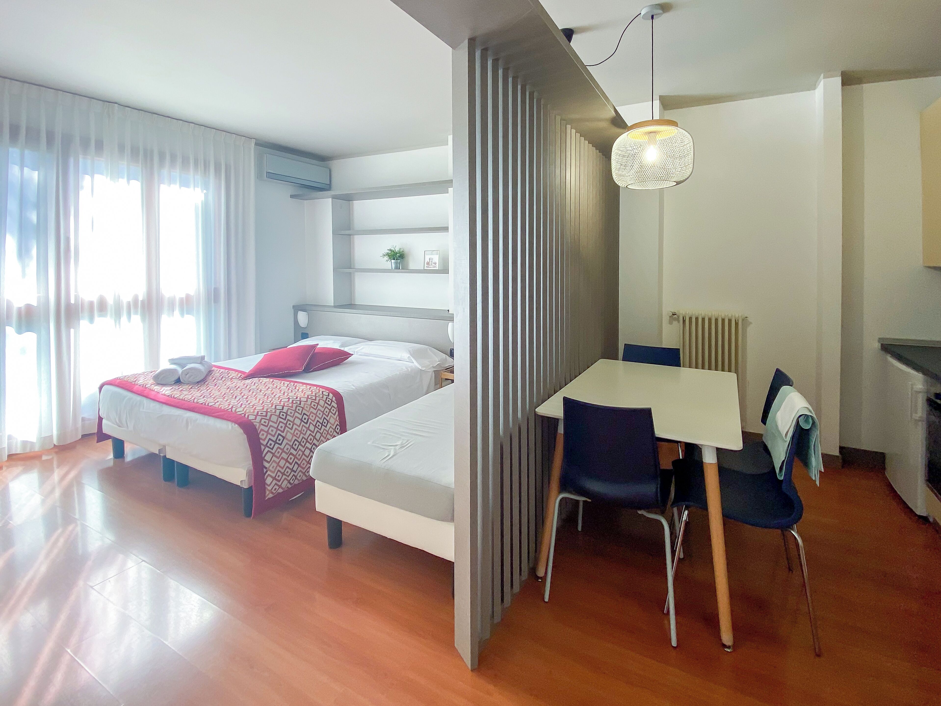 A modern hotel room with a bed, a desk, and a chair.