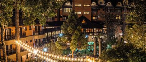 Un hôtel composé de plusieurs bâtiments, doté d’espaces extérieurs aménagés et illuminé de guirlandes lumineuses.