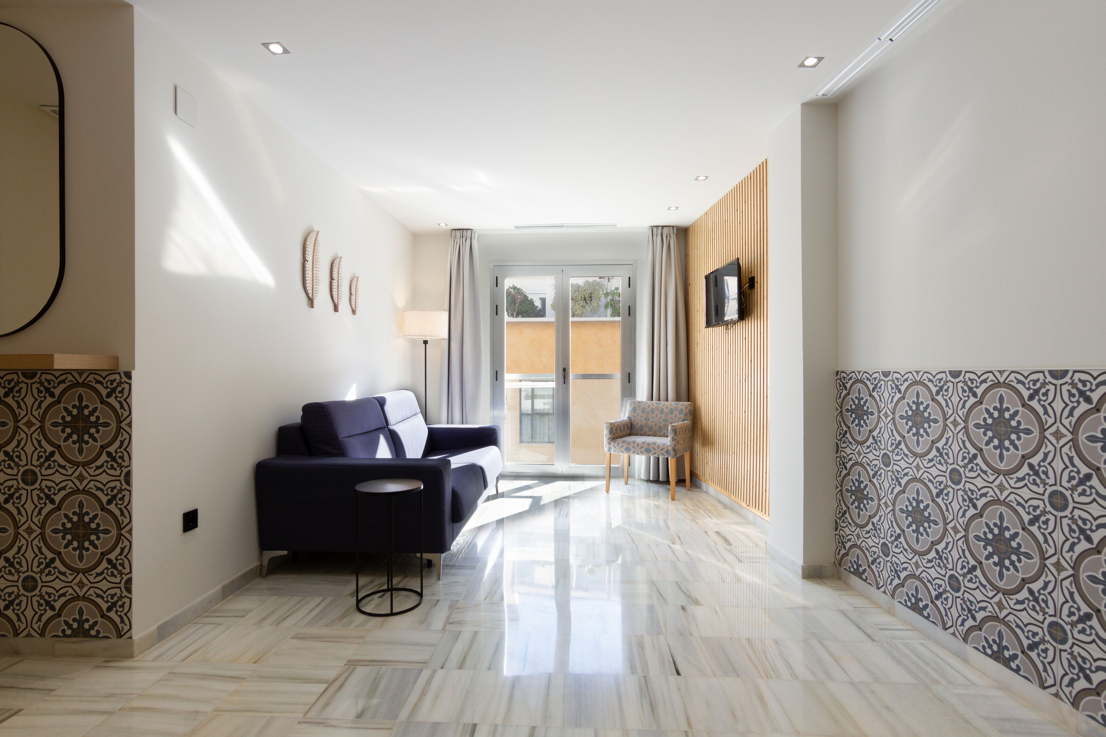 Un hall moderno de hotel con sofá, sillones y paredes con diseño.