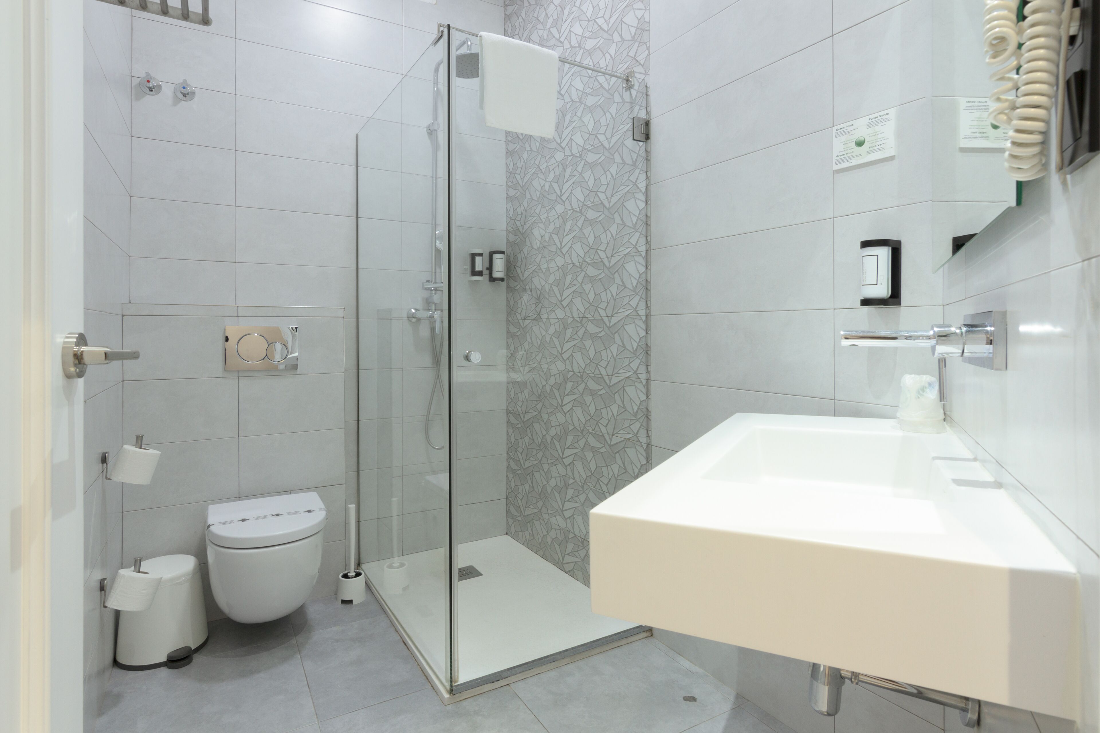 Une salle de bain moderne avec une douche à parois de verre, des toilettes et un grand lavabo.