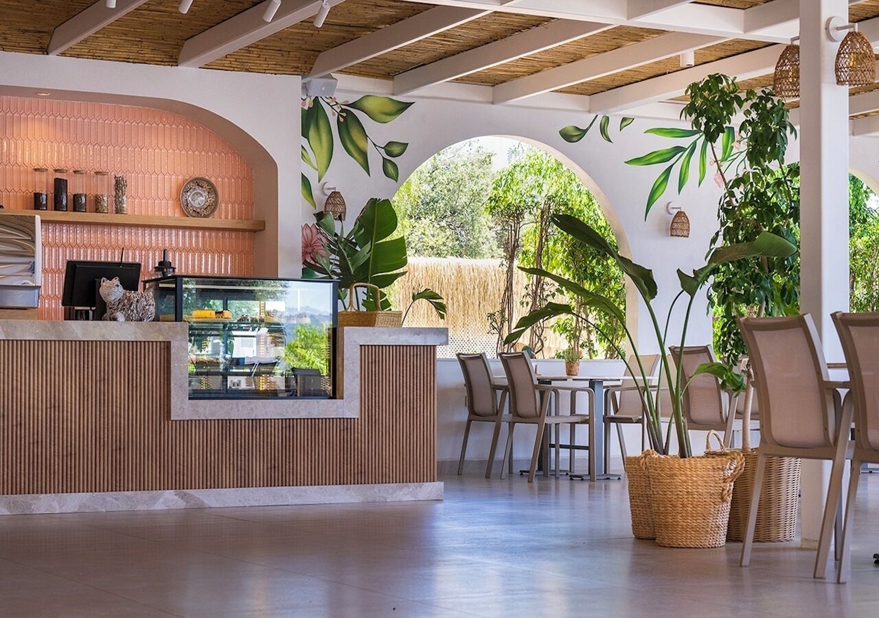 A modern outdoor dining area with a wooden counter, seating, and potted plants.