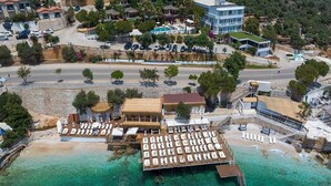 Vista aèria d'una estació turística costanera amb un moll, platja i diversos edificis.