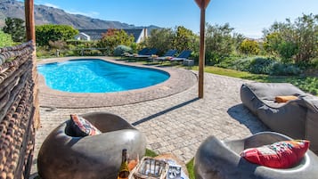 Een buitenzwembad en ligstoelen