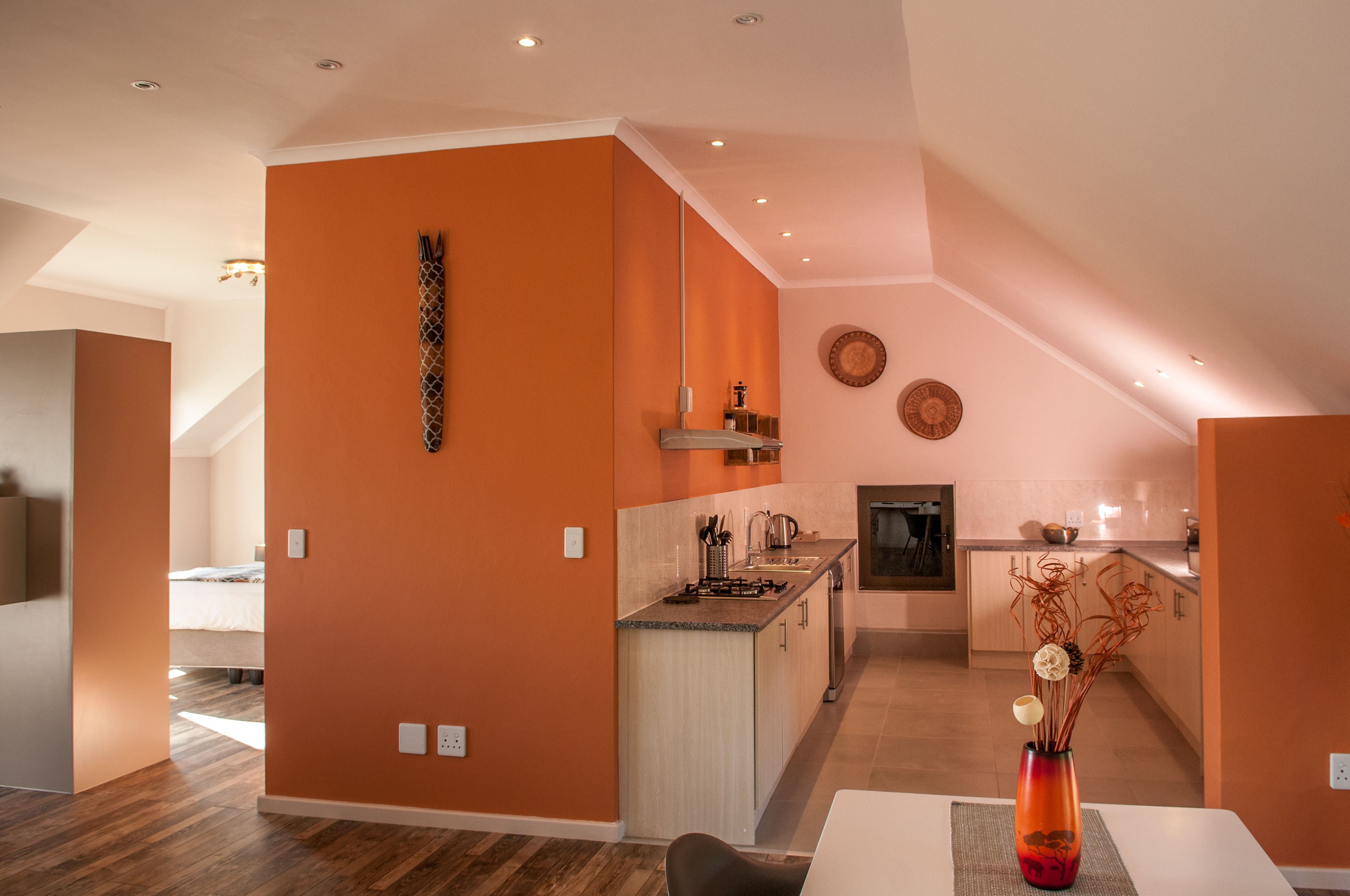 A modern kitchen with an island, a dining area with a table, and a living space with a sofa.