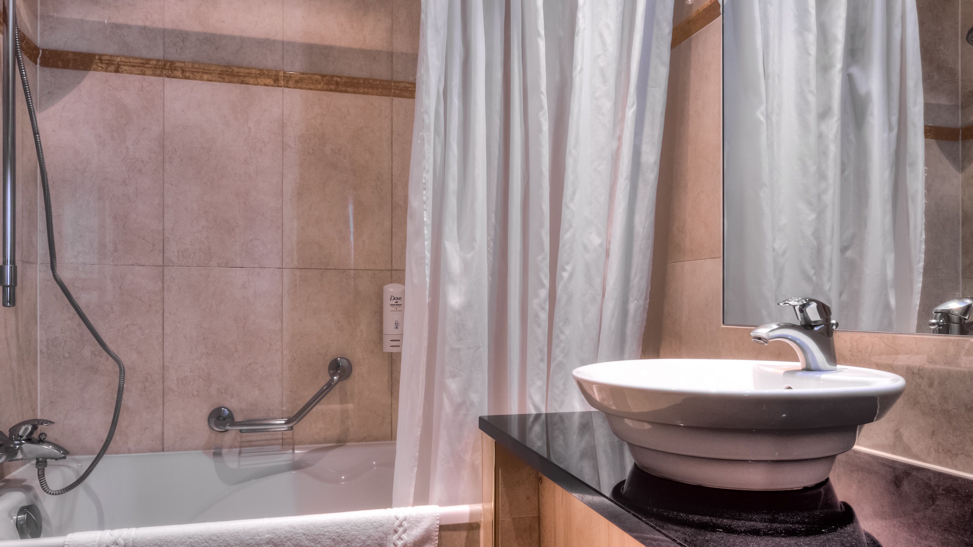 Een badkamer met een bad, een wastafel en een douche.