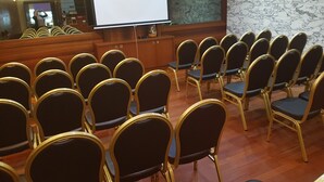 A conference room with rows of chairs and a large projection screen. - Tristar (La Louviere)
