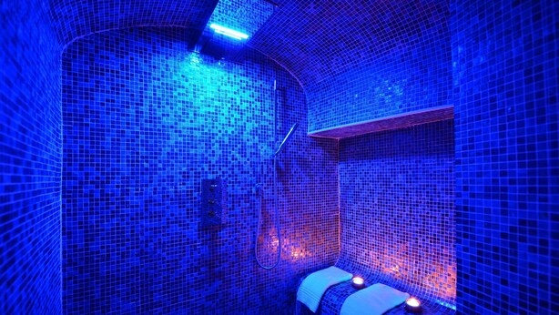 A room with mosaic tile walls and a curved ceiling.