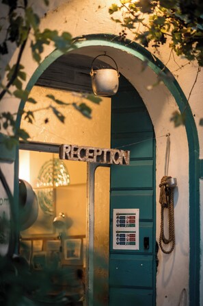 A reception area with a sign, a door, and a wall-mounted information board. - Agriturismo Beatilla (Marmirolo)